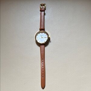Kate Spade Gold and Brown Leather Strap Watch with gold bow wind-up stem.